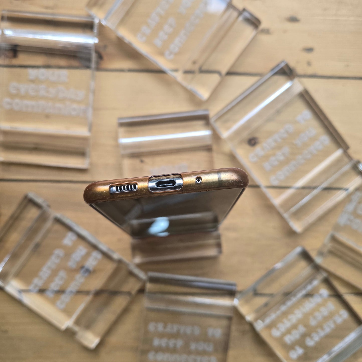 Minimalist plexi phone and tablet holder with engraved message. A stylish, functional stand for any desk or nightstand. The perfect everyday gift!