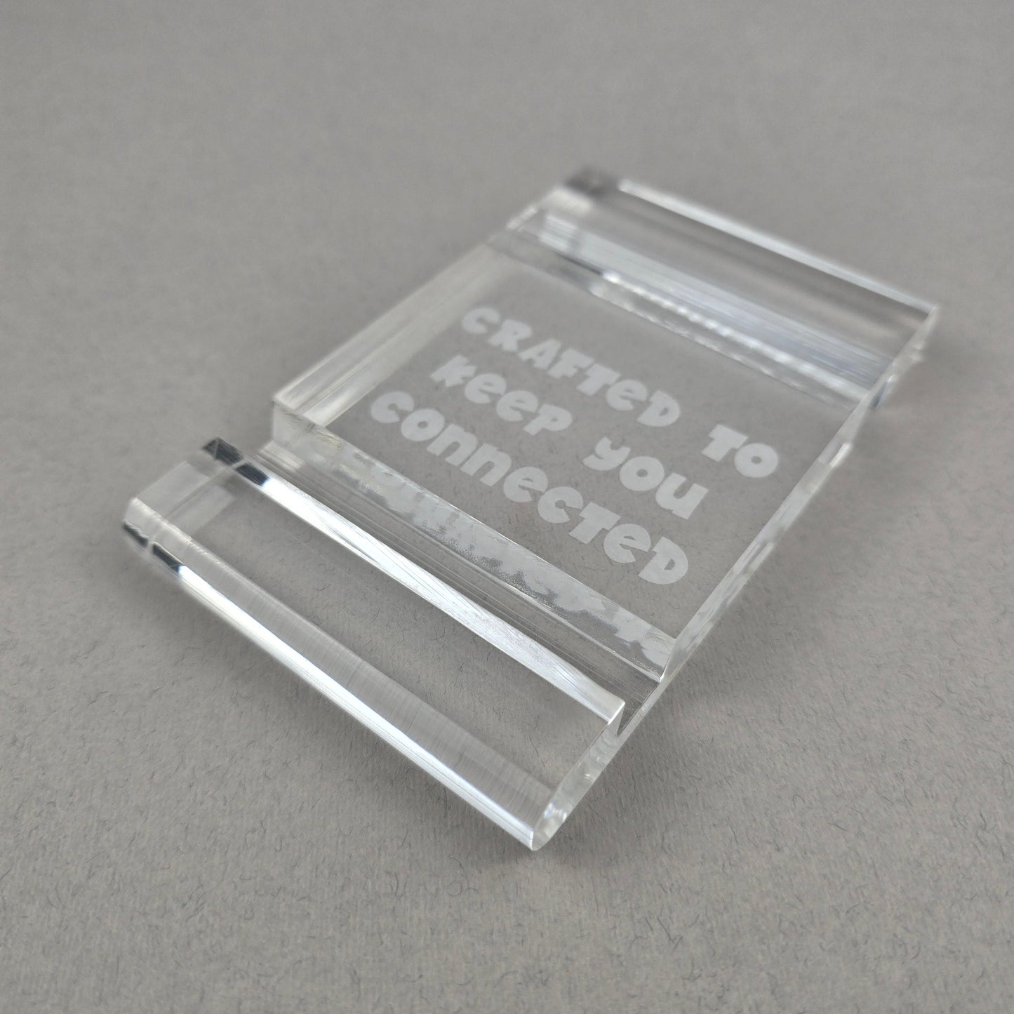Minimalist plexi phone and tablet holder with engraved message. A stylish, functional stand for any desk or nightstand. The perfect everyday gift!